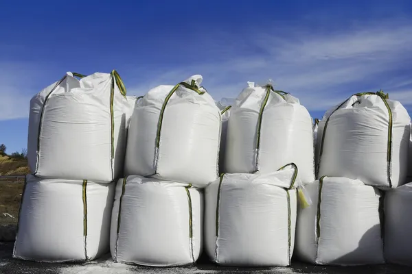 Salt white sacks rows stacked to road ice — Stock Photo, Image