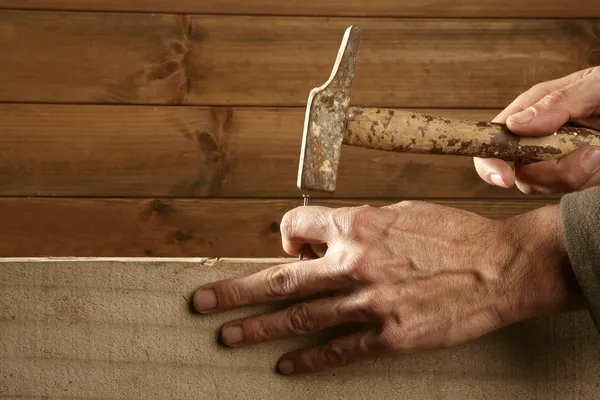 Manos de carpintero con madera de martillo y clavo —  Fotos de Stock