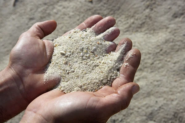 Areia de cascalho em mãos de homem em fundo de pedreira — Fotografia de Stock