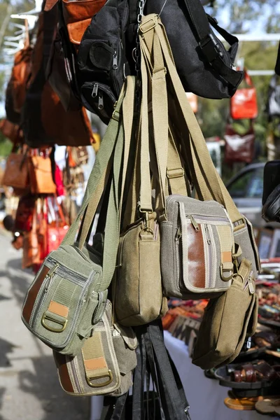 Bags hanging in market shop green khaki brown — Stock Photo, Image