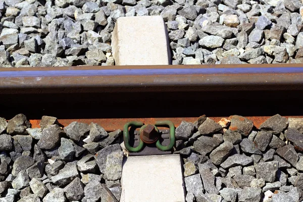 Ferrocarril de hierro oxidado detalle sobre piedras oscuras — Foto de Stock
