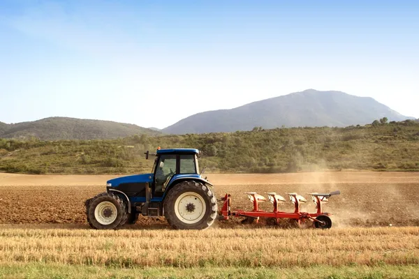 Jordbruk plöjning traktor på spannmål vetefält — Stockfoto