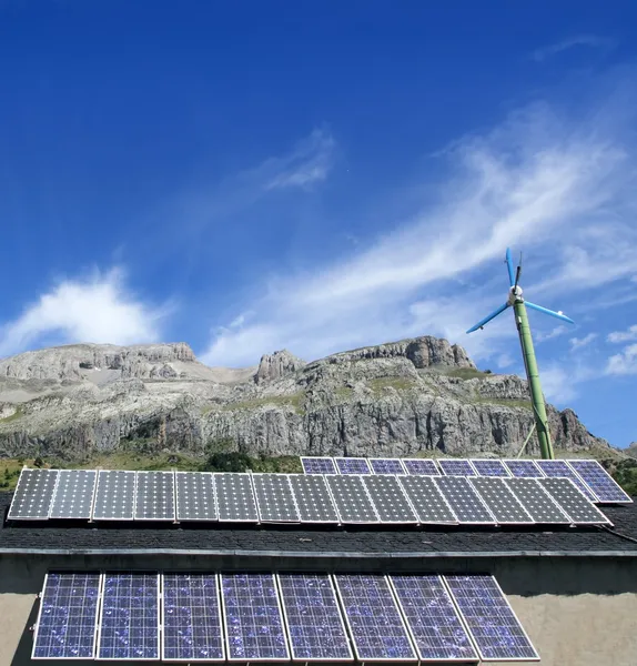 太陽電池板と青い空の下で風車 — ストック写真