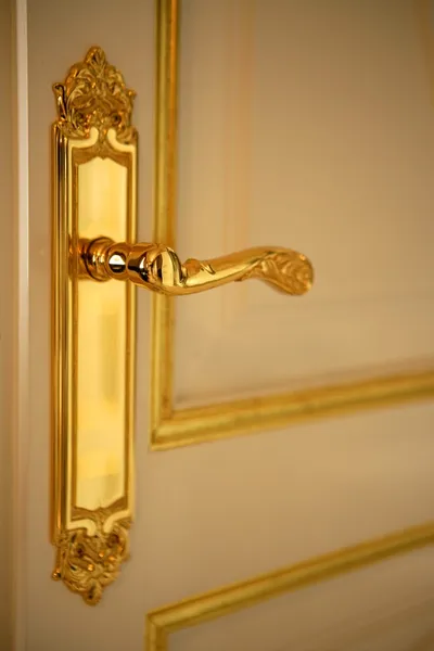 Золота дверна ручка, білі та золоті двері — стокове фото