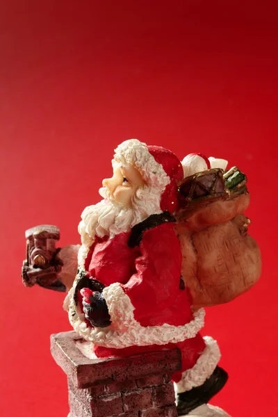 在红色的背景，圣诞老人公仔工作室 — 图库照片