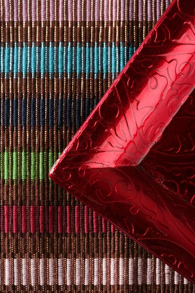Angolo cornice rossa su tovaglia multicolore — Foto Stock