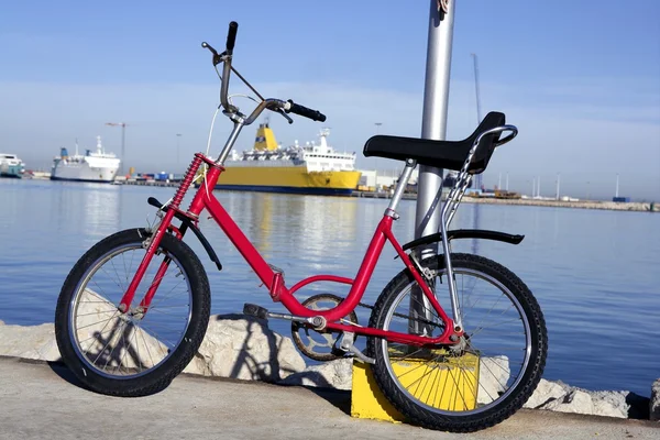 Bicycle parked in a harbour over blue water — Stock Photo, Image