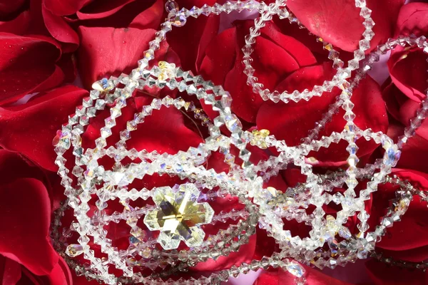 Λαμπερά κοσμήματα πάνω από πέταλα κόκκινων τριαντάφυλλων — Φωτογραφία Αρχείου