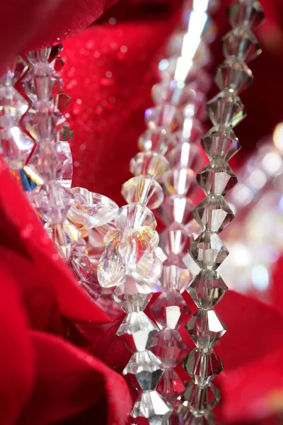 Glänsande smycken över röda rosenblad — Stockfoto