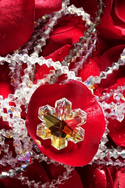 Shiny jewelry over red rose petals — Stock Photo, Image