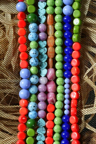 Цветные камни ювелирные колье, соломенный фон — стоковое фото