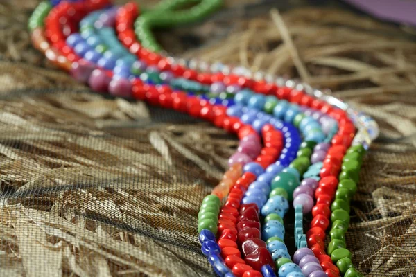 Collares de joyería piedras de color, fondo de paja — Foto de Stock