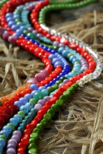 Color stones jewelry necklaces, straw background — Stock Photo, Image