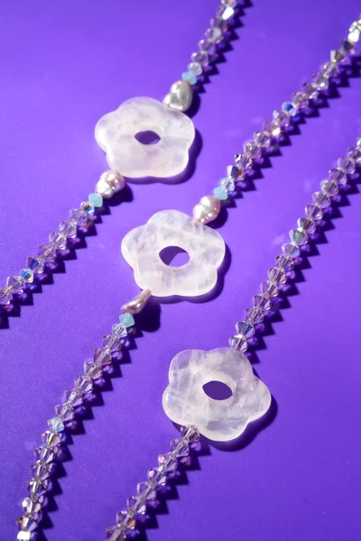 Färg stenar smycken halsband, lila bakgrund — Stockfoto