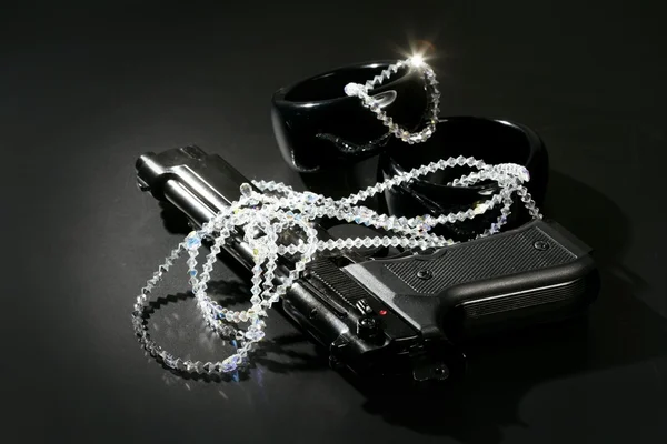 Pistolet i klejnoty nad obrazem czarnej, klasycznej mafii — Zdjęcie stockowe