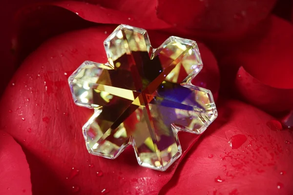 Schöne sternförmige Glasjuwelen, rote Rosenblätter — Stockfoto