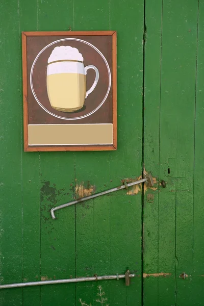 ビール緑の木製のドアにポスターを描く — ストック写真