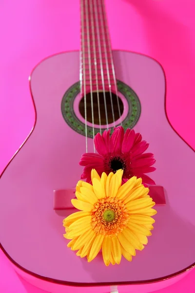 Hippie flower yellow pink gerbera on guitar — Stock Photo, Image