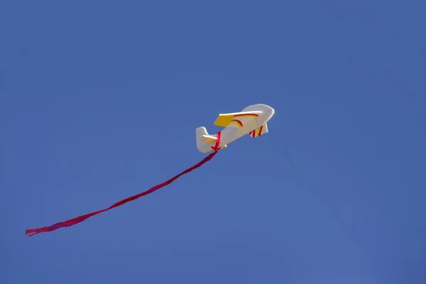 Воздушный змей, летящий на голубом солнечном небе — стоковое фото