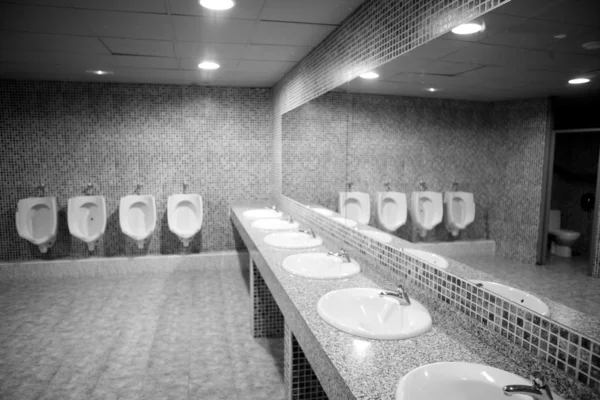 Bathroom urinal in a row with gray tiles — Stock Photo, Image