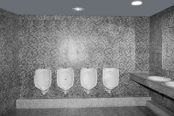 Туалетный писсуар в ряд с серой плиткой — стоковое фото