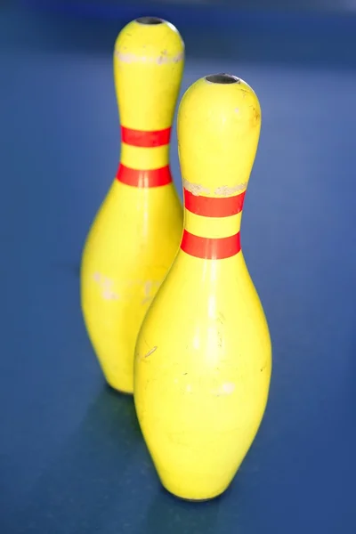 Bowling de couleur jaune nature morte fond bleu — Photo
