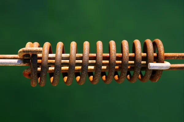 Aged mooring rusted spring on green water — Stock Photo, Image