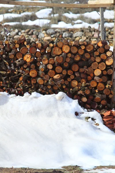 Firewood empilhado no inverno neve ao ar livre — Fotografia de Stock