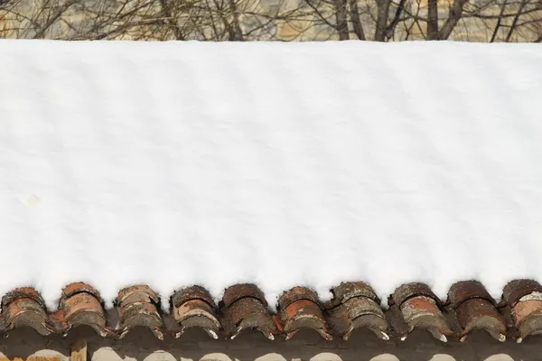 Telhas de barro envelhecido nevou sob neve de inverno — Fotografia de Stock