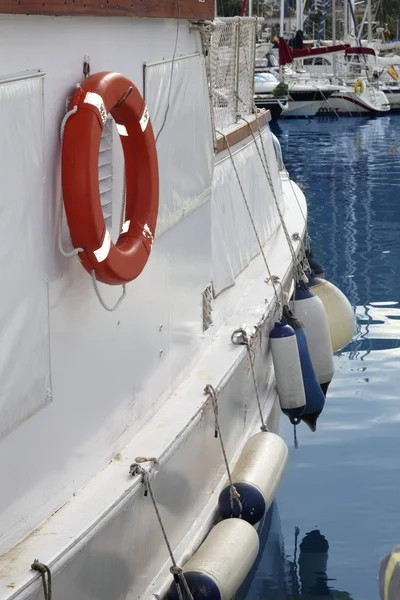 Белая лодка с крючком и круглым спасательным кругом — стоковое фото