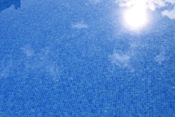 Blue tiled swimming pool with sun reflexion — Stock Photo, Image