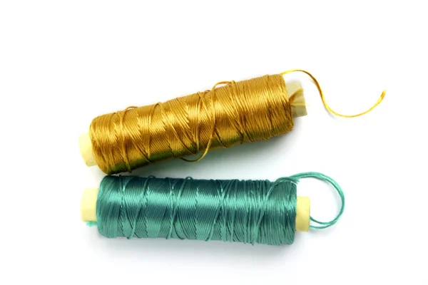 Metallic rayon thread line spool green and gold — Stock Photo, Image