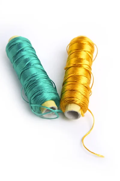 Metallic rayon thread line spool green and gold — Stock Photo, Image
