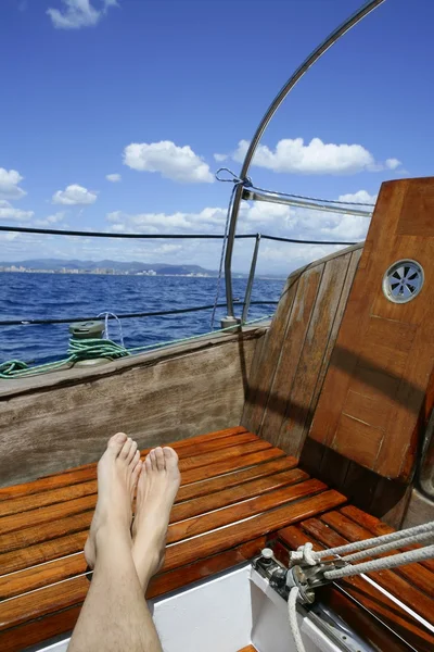 Homem pés relaxar no veleiro velho de madeira dourada — Fotografia de Stock