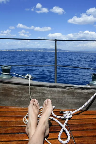 Man feet relax on golden wooden old sailboat — Stock Photo, Image