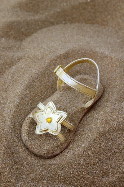 夏のビーチの砂に埋もれてゴールデン スター サンダル — ストック写真