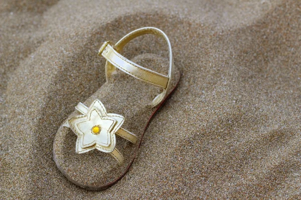 Sandalia estrella dorada enterrada en arena de playa de verano — Foto de Stock