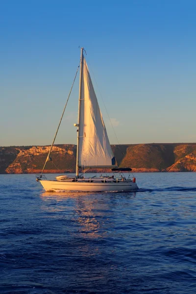 Zeilboot zeilen gouden zonsopgang in blauwe oceaan — Stockfoto