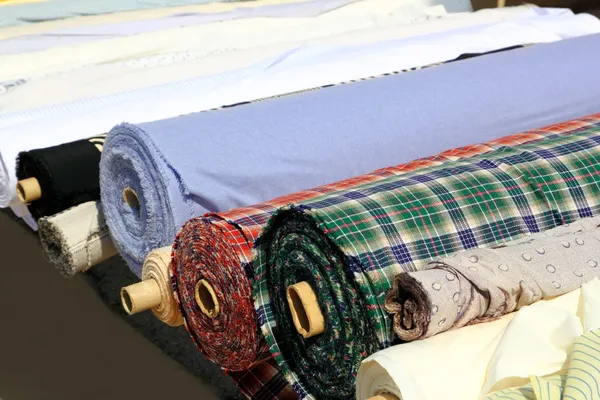 Colorful fabric rolls row in market shop — Stock Photo, Image