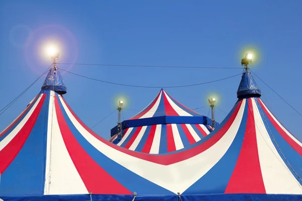 Circus tent under blue sky colorful stripes