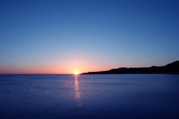 Восход солнца над синим морским океаном — стоковое фото