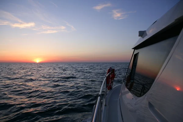 Hermoso amanecer puesta de sol sobre el mar azul en un yate — Foto de Stock