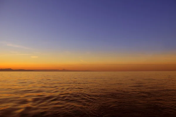 Üzerinde mavi deniz okyanus kırmızı gökyüzü günbatımı güzel gündoğumu — Stok fotoğraf