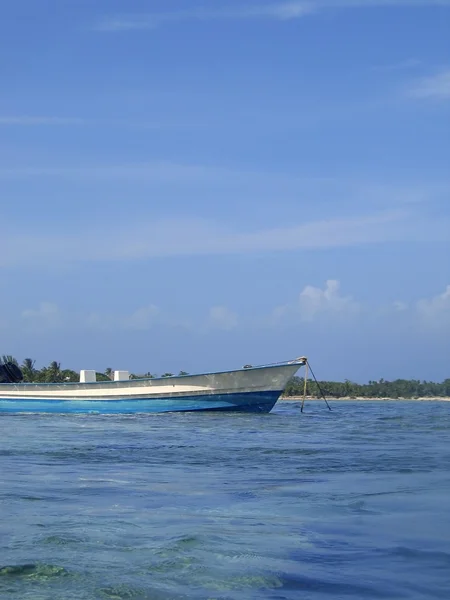 Blå båt ankare på grunt shore vatten — Stockfoto