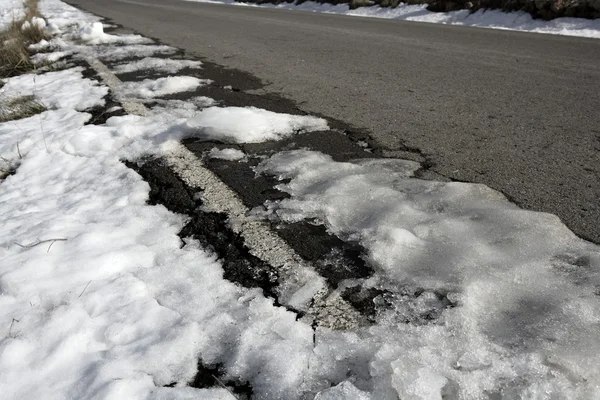 Nieve en el camino de asfalto ocultar las líneas blancas — Foto de Stock