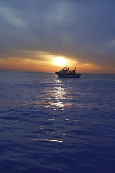 Zonsondergang zonsopkomst met vissersboot in horizon — Stockfoto