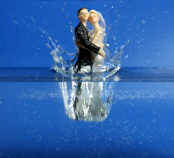 Svatební figurka padá do modré vody — Stock fotografie