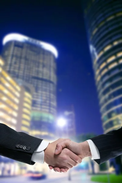 Партнеры по бизнесу пожимают друг другу руки с иском — стоковое фото