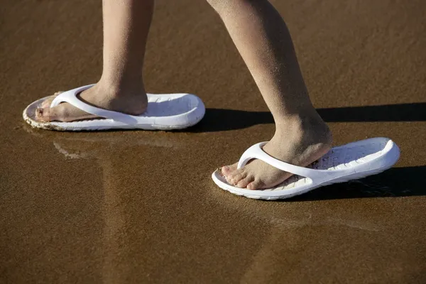 Adult shoes for children feet on beach sand — Stock Photo, Image