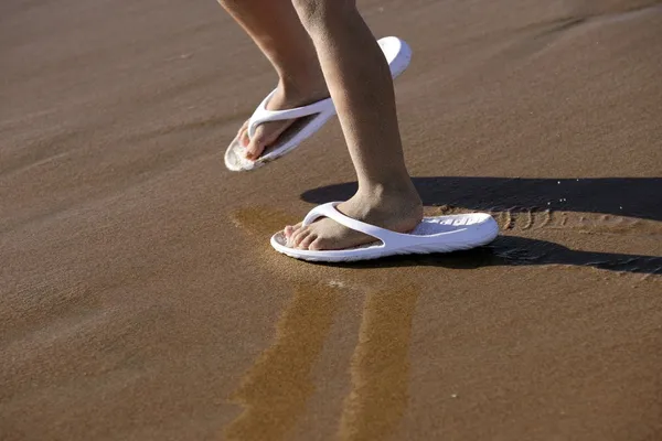 Ενηλίκων παπούτσια για τα πόδια τα παιδιά στην άμμο παραλία — Φωτογραφία Αρχείου